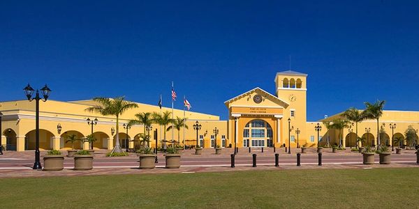 Wide view of a yellow civic center building under a clear blue sky.