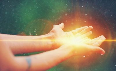 Hands holding a glowing light.