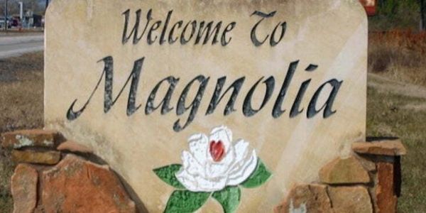 Welcome sign to Magnolia with a flower illustration.