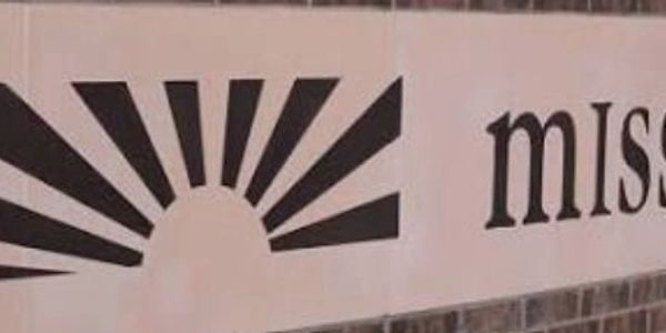 Black sunburst design next to partial text on a sign.