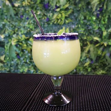 Refreshing lime margarita with salted rim and lime wedge.