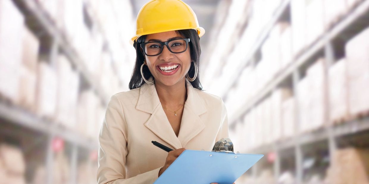 happy lady with safety checklist wearing yellow safety hard hat