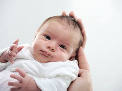 Postpartum doula holding newborn.