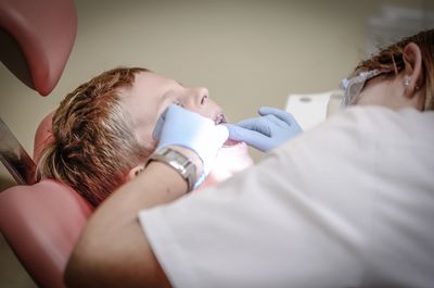 A kid being examined by a dentist