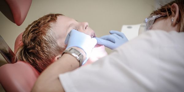 The Dentist is examining the patient's teeth.