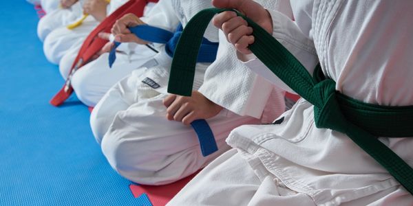 Kids and other students kneeling showing respect in the Dojo during their Karate Classes