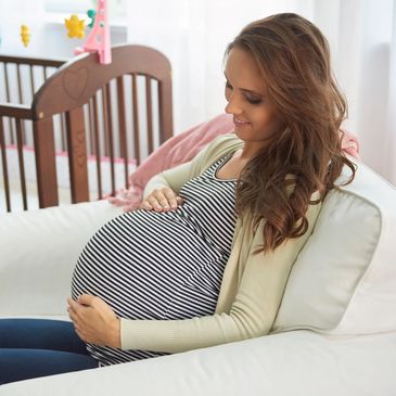 A pregnant woman who is holding her belly. Pregnancy chiropractic. 