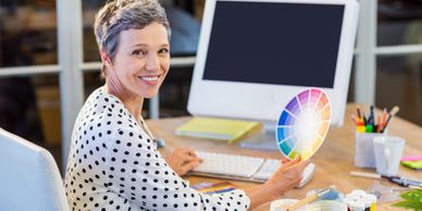 Woman working and holding up a color chart for design.