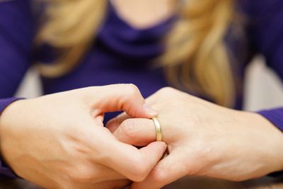 Woman with hands crossed focusing on her wedding ring