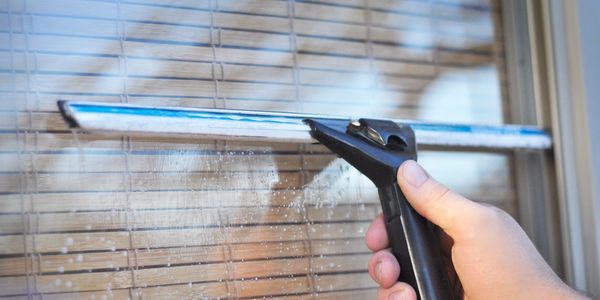 This image shows a squeegee against a window being cleaned. 