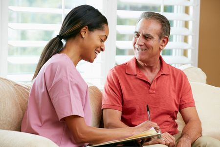 Intake process. Woman interviews male client to determine his needs, both smiling, she writes notes.