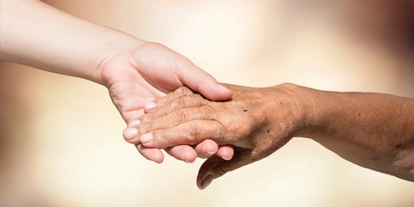 Child and elderly person holding hands