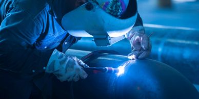 Man welding a large pipe. Day One Experts help connect business owners to communities for incentives