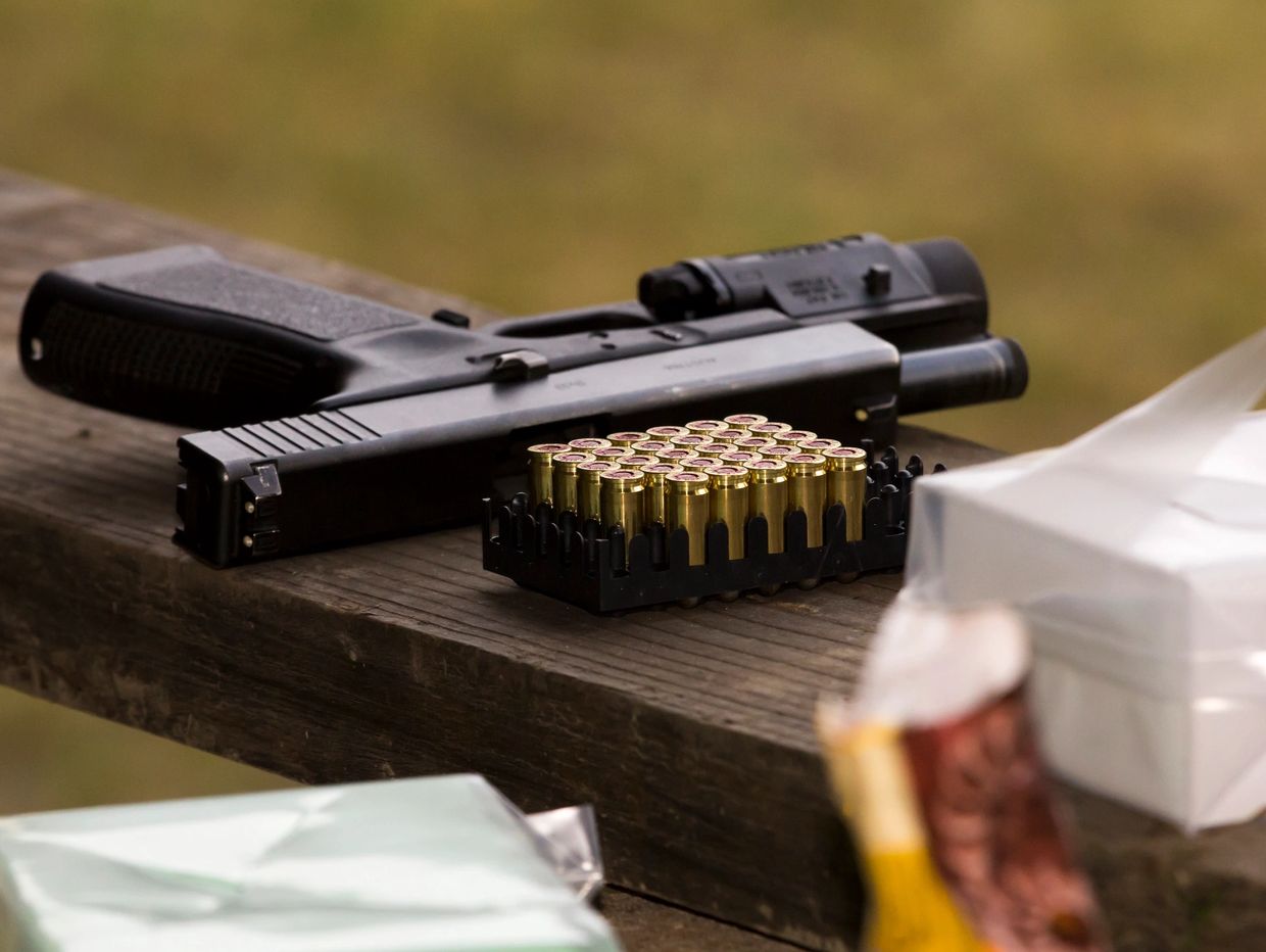 Pistol on wood with ammunition.