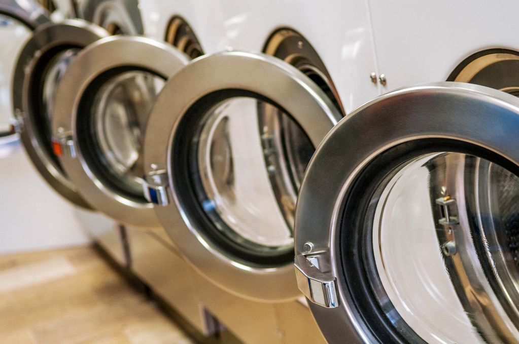 Row of front load washers in a commercial laundry facility.