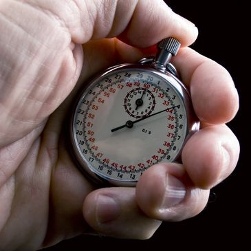 Image of hand holding a round stop watch indicates control of time with the Angle-Rite clamp.