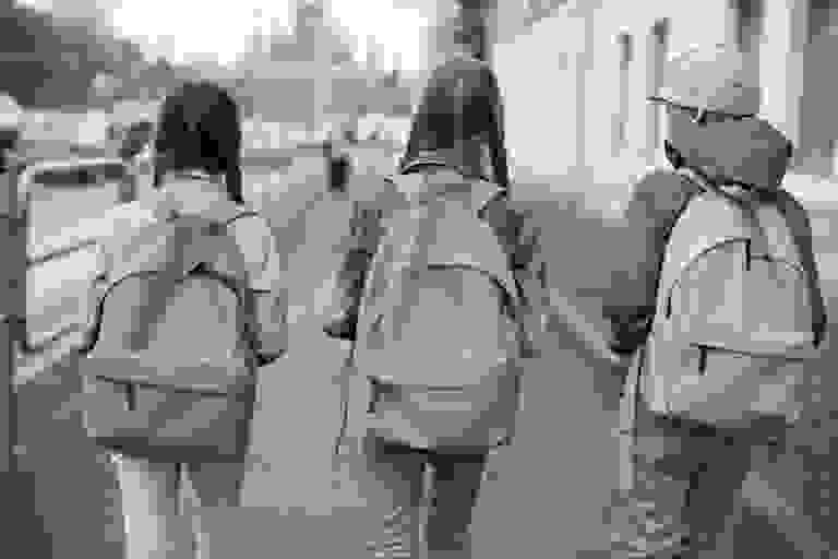 Three children with colorful backpacks.