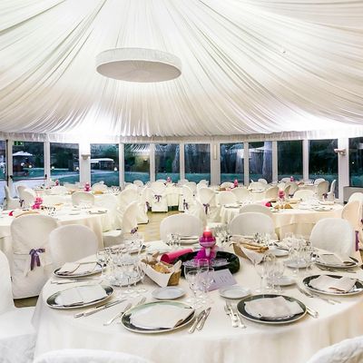 The interior of a large events tent with tables ready for a wedding