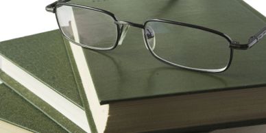 Pair of spectacles on a stack of books.