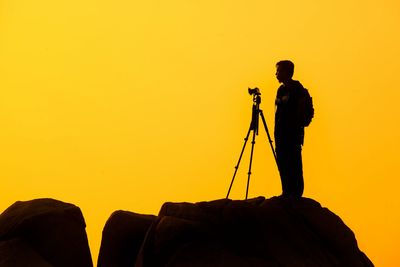 Photographer silhouetted against  a yellow sky
