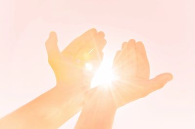 Hands with sun shining through