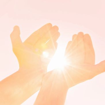 open hands with the sun pouring through, energy and light create qi for health and well-being