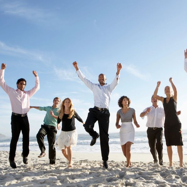 group of business people on the beach celebrating
