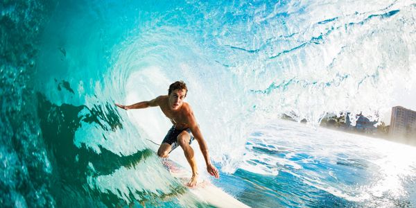 A man surfing a barrel wave.