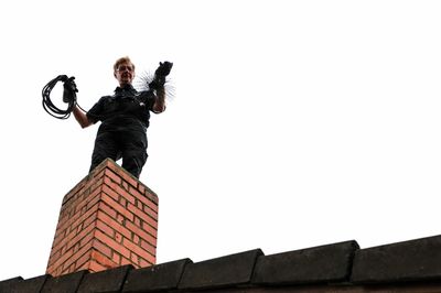 Chimney sweep cleaning a chimney