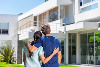 Couple embracing and looking at new home. Home buyers
