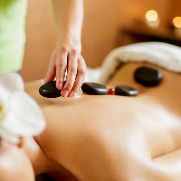 Hot Stones therapeutic massage been applied on the back to relieve pain