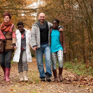 Interracial family smiling and walking in woods