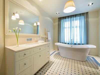 Clean bathroom with a white tub and vanity