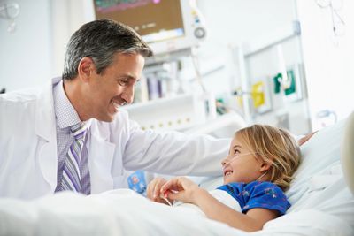 Doctor talking to a kid in a hospital bed
