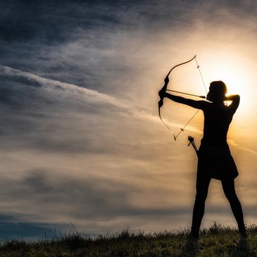 Archer in outline shooting an arrow into the sky.