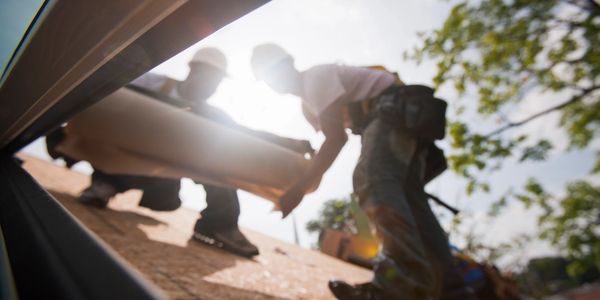 Stock photo of two men working on a residential roof.