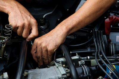 Mechanic's hands performing auto repair in auto shop 