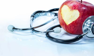 A stethoscope, and apple with a heart carved on it 