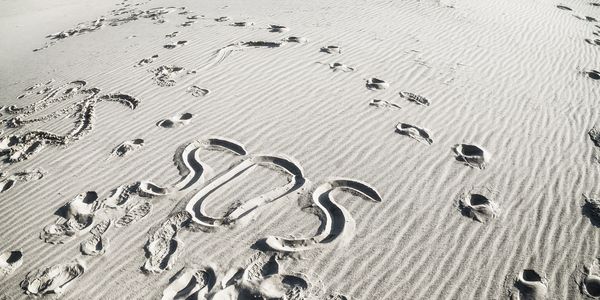 SOS message in sand
