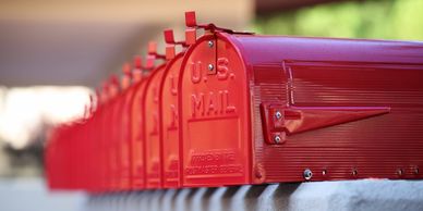 a row of red rural mailboxes one after another. at least 10 or more in a row.