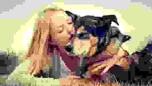Woman kissing a dog.
