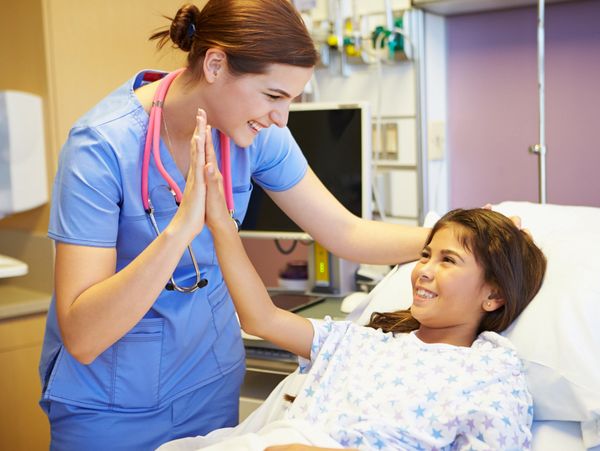 Nurse giving a pediatric patient a high five 