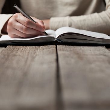 Person writing in a journal.
