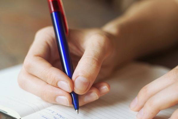 A person writing on a notebook