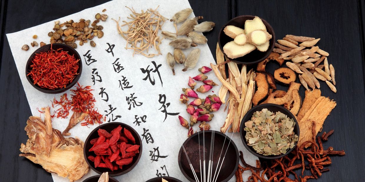Assortment of chinese herbs on parchment paper with chinese lettering