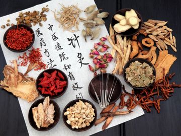 Assortment of chinese herbs on parchment paper with chinese lettering