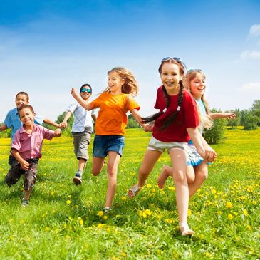 Group of older children running through a field
