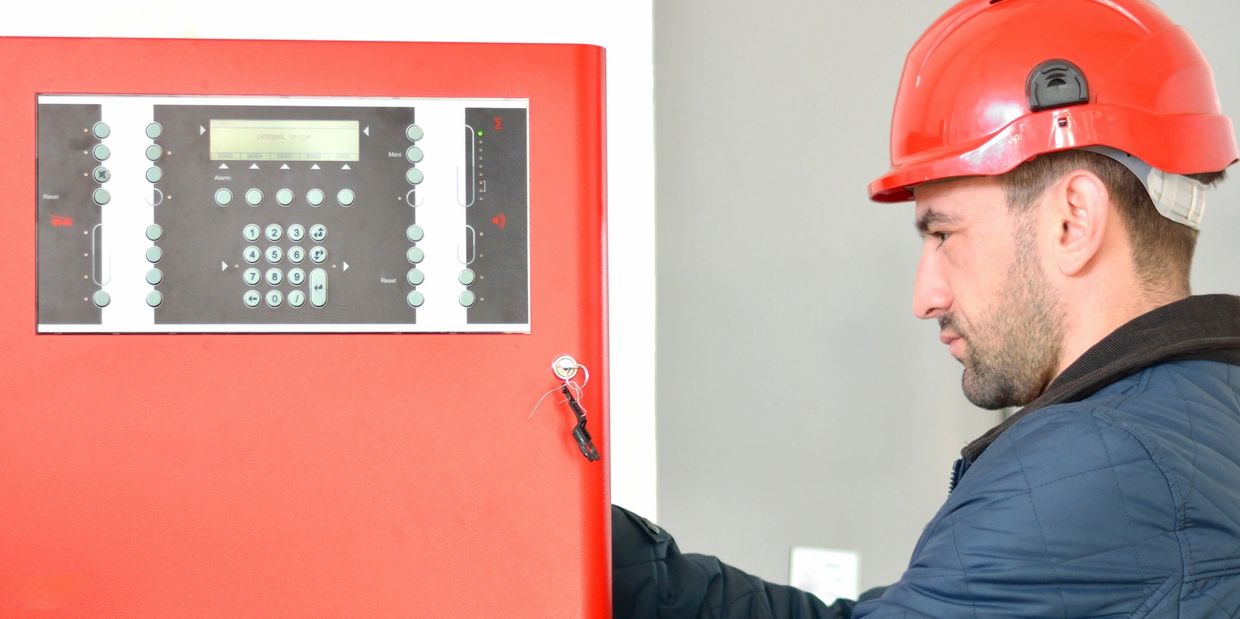 A Technician Working on a Fire Alarm System. 