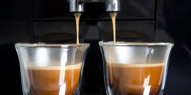 two cups of coffee under coffee machine