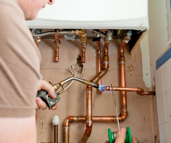 Doing some copper water lines repair in a on demand water heater , plumbing service solutions 